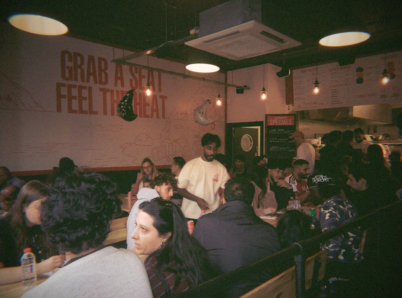Inside Firepitt, with Grab a seat, feel the heat painted on the wall
