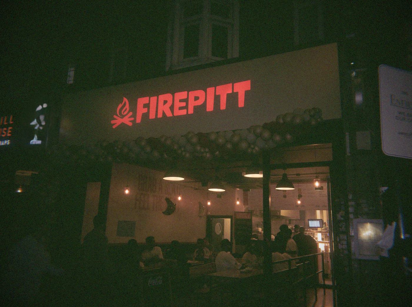 Firepitt shopfront at night with its red neon sign