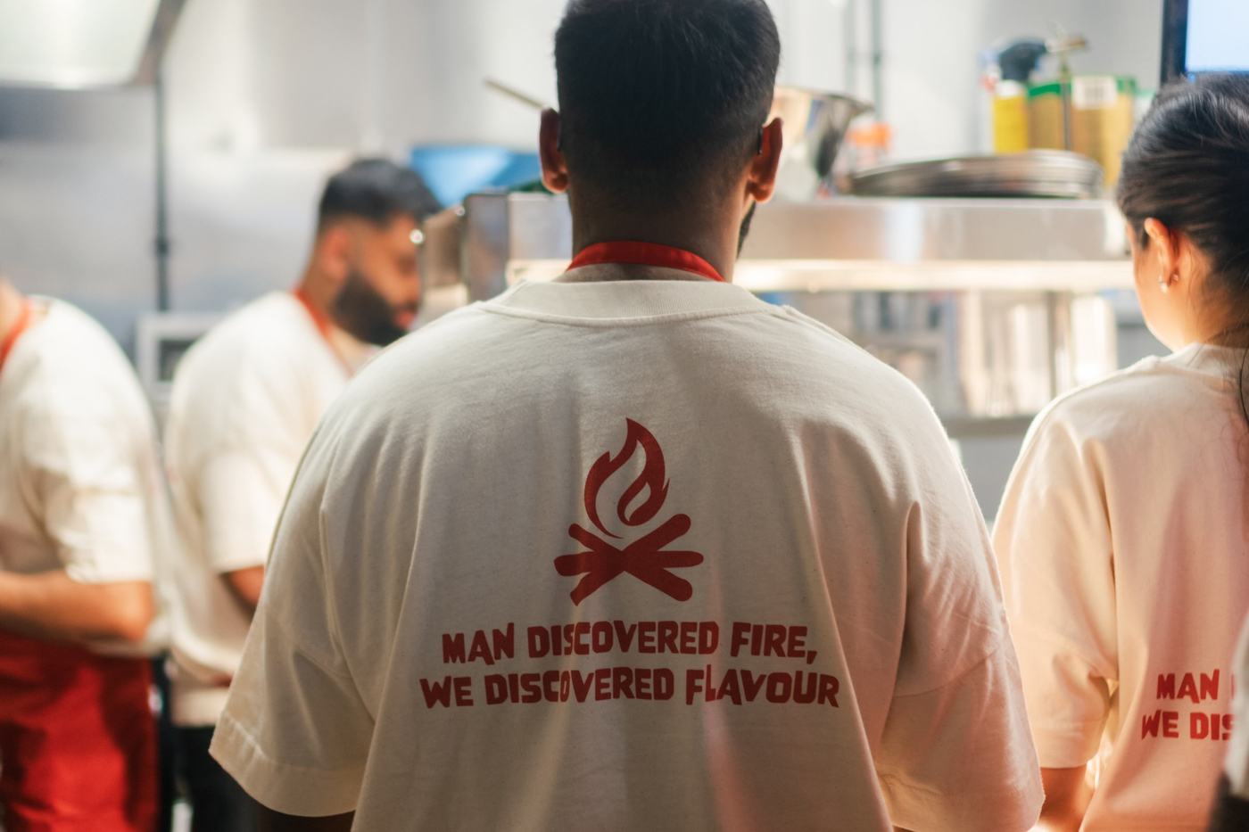 Firepitt crew member wearing a tee that reads Man discovered fire, we discovered flavour